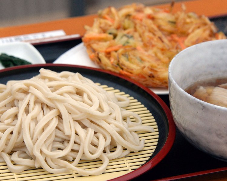 灰色がかったうどん。もり・かけ520円〜、ジャンボかき揚げ110円。