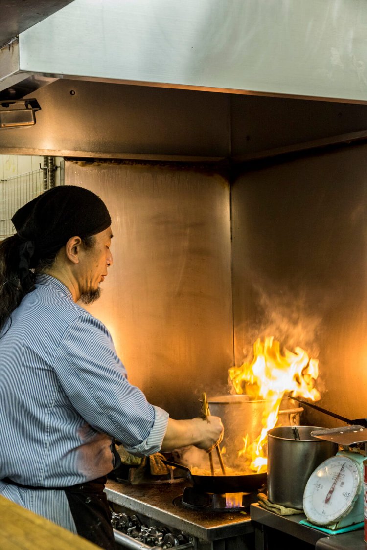 厨房に立って30年以上の店主が1人で調理を担当。3口のコンロはフル稼働。