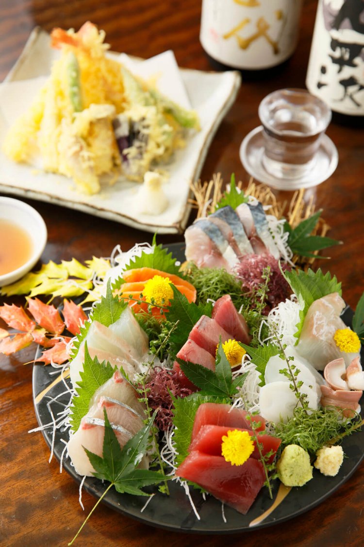 刺し盛り2人前3000円。当日はカツオや熟成させたサーモンにヒラメなど全9種。エビやキスなどを揚げた天ぷら盛り合せ2人前2800円。日によっては十四代本丸1200円などの銘酒も。