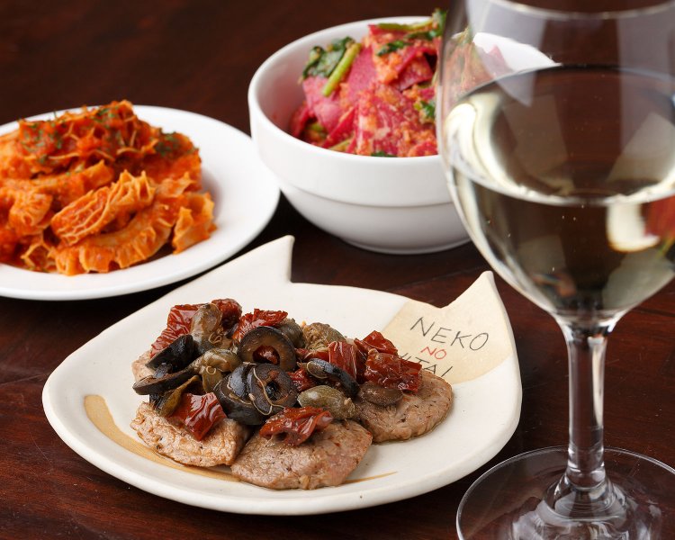 豚肉のソテーのケッパーとドライトマトのマリネ660円など。ワインは計10数種で550～880円。オレンジワインなども用意。