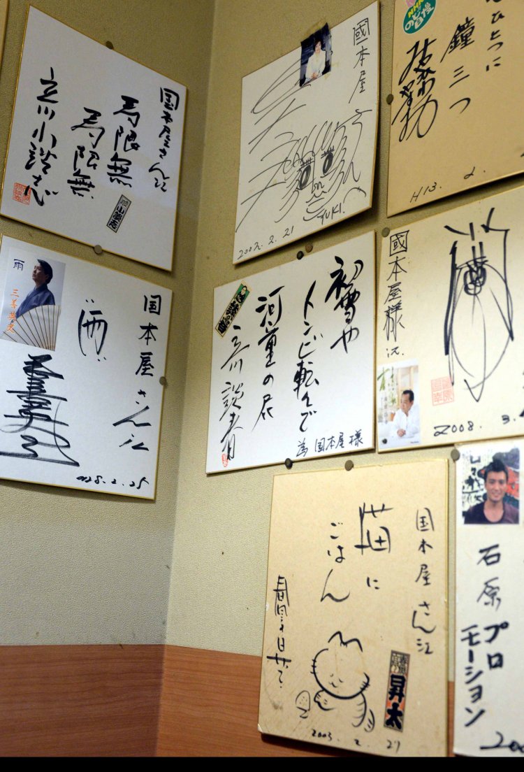 定期的に寄席が開かれる国本屋旅館の食堂に飾られた落語家の色紙。