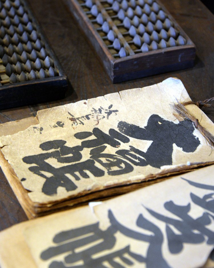 大福帳や五つ珠のそろばんなど、当時商いに使われた貴重な品々。