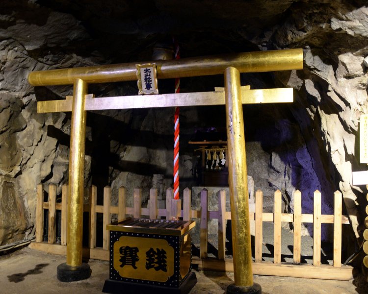 純金箔張りの黄金の鳥居が立つ観光坑道内の山神社。金運パワースポットとして人気。