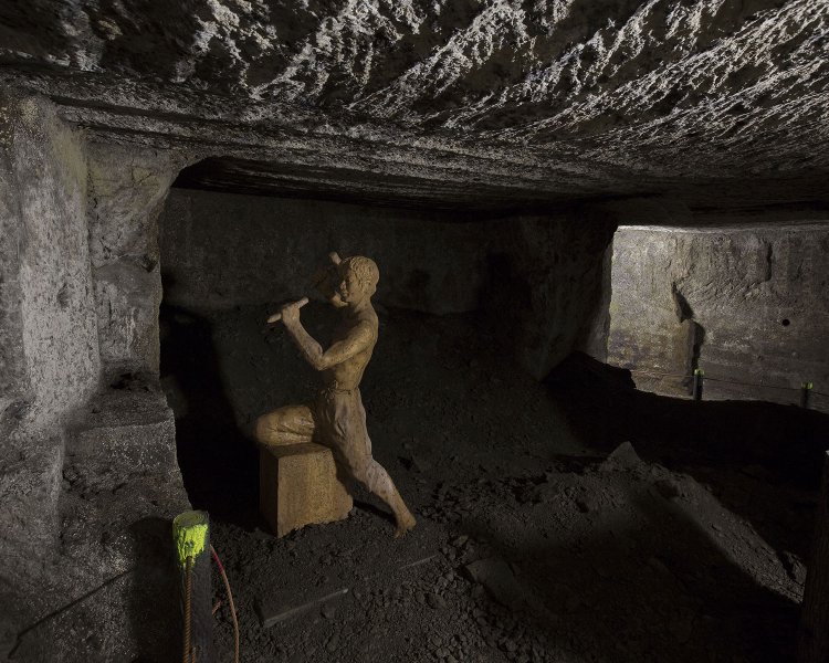 トンネル状になった石丁場跡。地層や手掘り採石の痕跡が見どころ。
