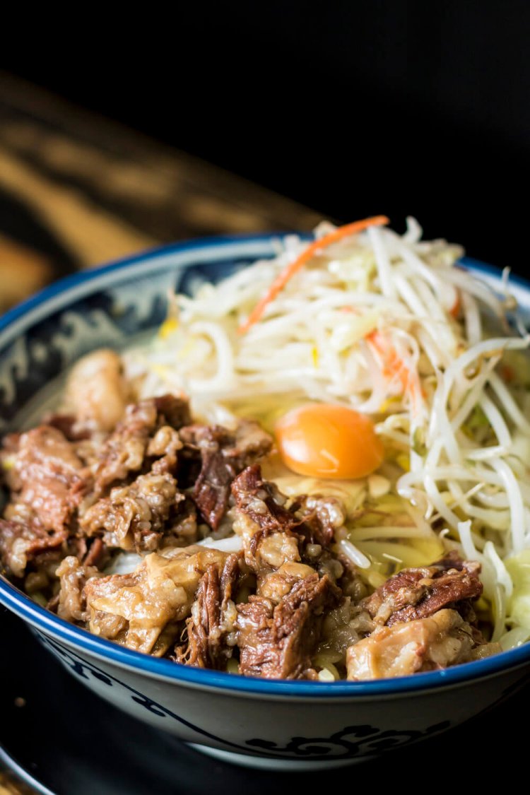 定番の牛すじぶっかけ900円は生卵入り。