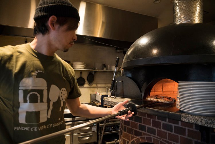 薪窯の火力を見ながら、ナポリピッツァを1分で焼き上げる。