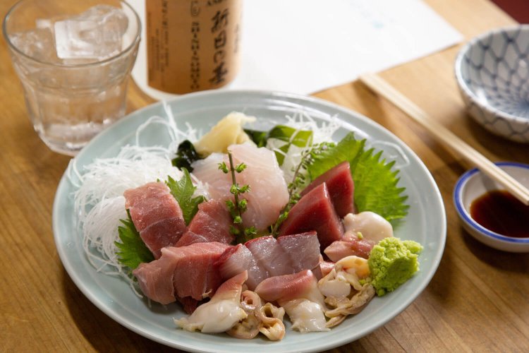 刺身の盛合わせ2800円。創業70余年を記念した米焼酎「新日の基」はボトル2500円。