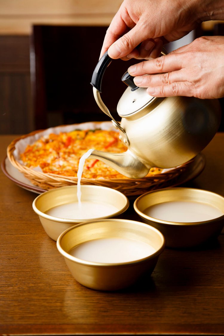 空輸で届く韓国産ネギ入り海鮮ネギチヂミ1490円をツマミに、生マッコリで乾杯。