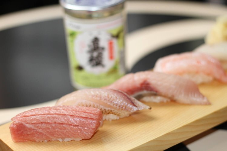 握り5貫セット990円。この日は手前から本マグロ中トロ、ノドグロ、ブリ、南蛮海老、活ヒラメ。佐渡の地酒・真稜550円。