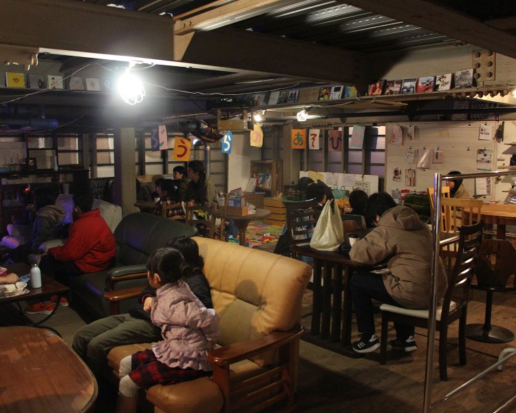 建物2階のスペース。食事をしながらくつろいでいる家族が多い。