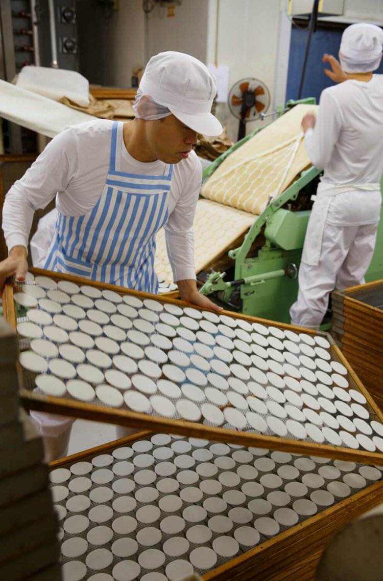 せんべい作りは自社で精米するところから。店の奥で生地を作っている。