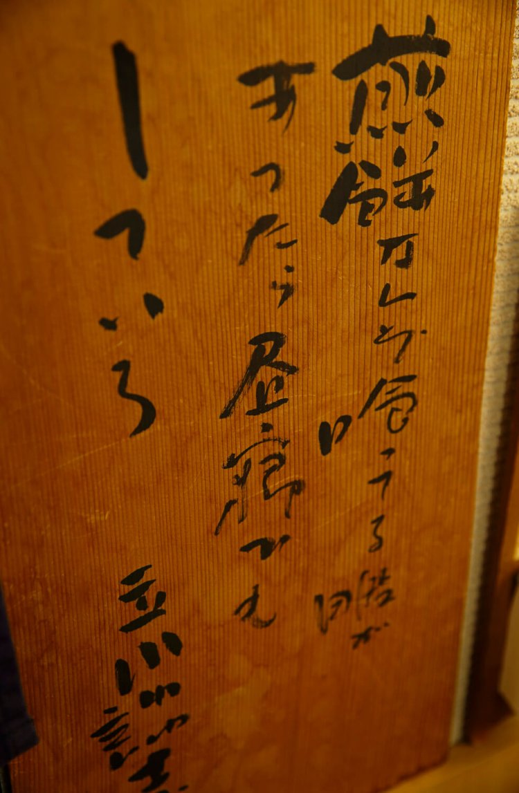店舗が入るマンションの階上に、立川談志が住んでいた。店に直筆の標語も残る。