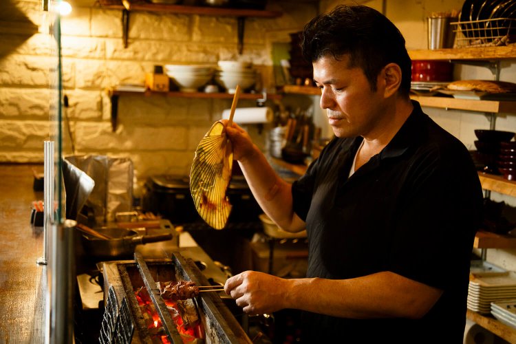 備長炭で鶏を焼く店主。