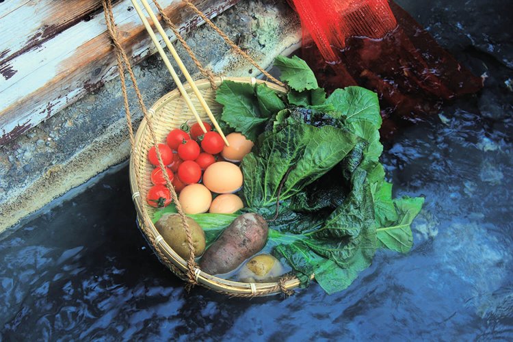 湧き出る90度の熱湯で卵や野菜を自由に茹でられる川沿いの湯筒。