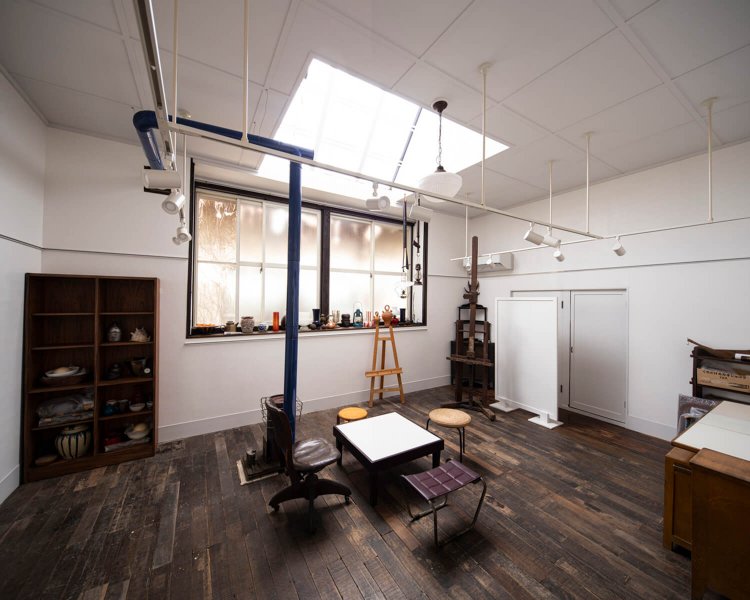 春日部さん夫妻は壁を合板で耐震補強し、床を剝がして基礎に鉄骨を増打ちして補強した。日中は一切電気をつけずにこの明るさ。調度品は西田さんのものをそのまま置いている。一口のIHコンロとシンクがある。