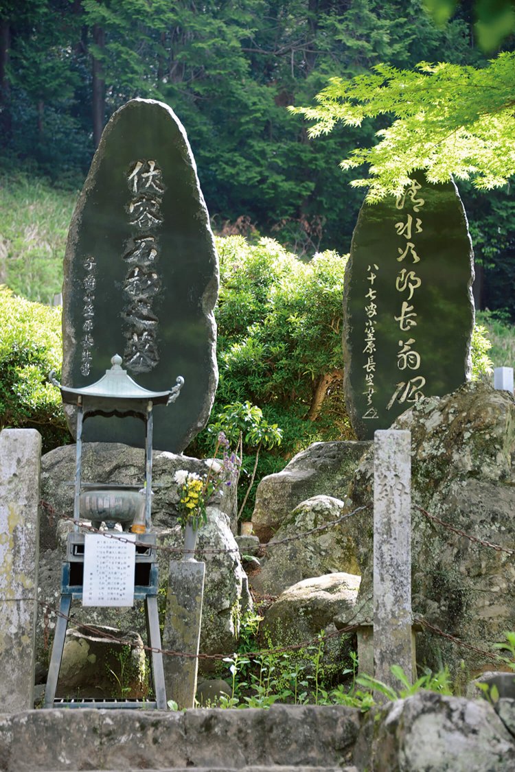 大洞院にある石松の墓。墓石のかけらを持つと 賭け事に強くなるといわれ文字の周囲が削られて しまった。墓前にパチスロのメダルが散らばる。
