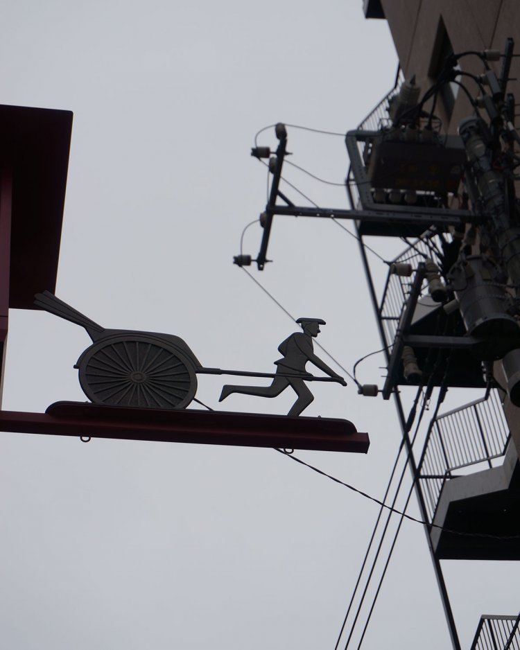 車力門通りの名前の由来は、松平摂津守の上屋敷があった頃、物資が荷車で運び込まれた道だったことから。入り口のゲートの上には車力のオブジェが。