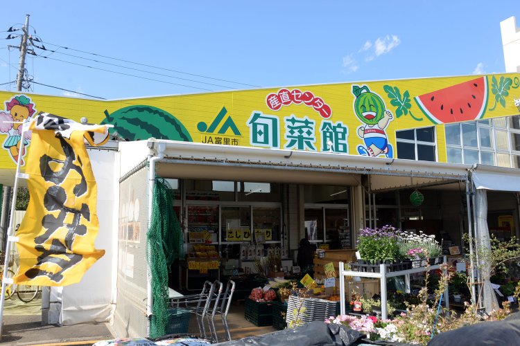初夏にはスイカが店頭に並ぶ。看板には市のキャラ「とみちゃん」。