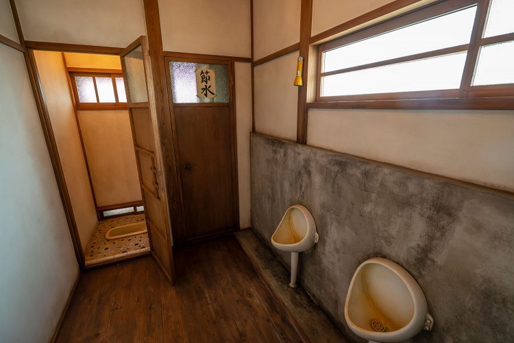 2階の住人用の便所。男女共用。大便器で用をたすと、土管を通って下に落ちる仕組みだった。※再現のため使用不可