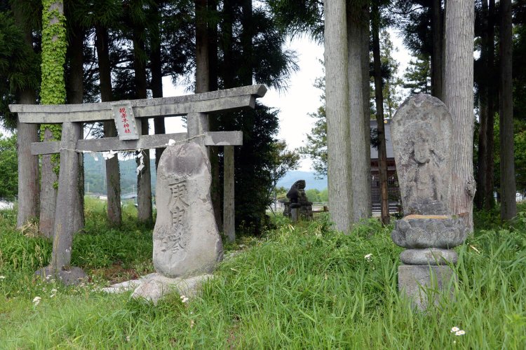田園にポツンと鎮座。鳥居の脇に二十三夜塔、庚申塔、石仏が並ぶ。
