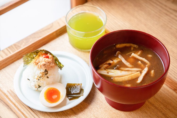 きのこと油揚げ、焼きネギの味噌汁とスパイシーツナおにぎりのセット600円。煮卵とお茶付き。