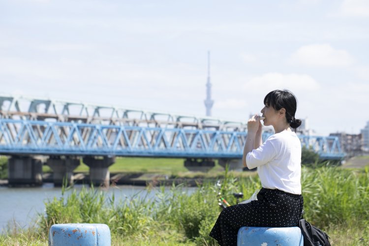 【かぶりつくならココ！】荒川河川敷。茂みに隠れた小道を進むと、穴場の椅子を発見。川を見ながらぱくり。