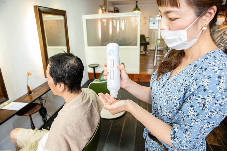 冷たいローションを頭皮に擦り込む。