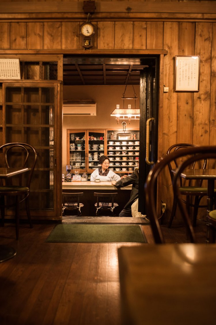 蔵の奥にあるテーブル席は、建物の重厚感も、カウンターの景色も両方楽しめる特等席。蔵の入り口には、金網の格子引き戸が当時のまま。