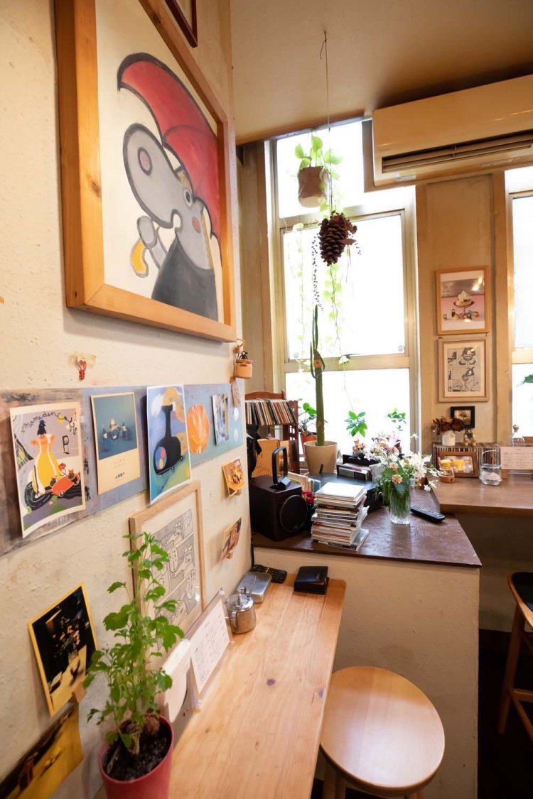 絵本の世界のような絵画が壁を飾る。写真はお客さんの作品。