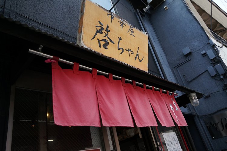 真っ黒な外観に、赤い暖簾が鮮やか。