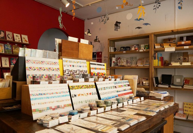 店内は壁面やテーブルの上だけでなく、天井からも紙モノ雑貨でいっぱい。