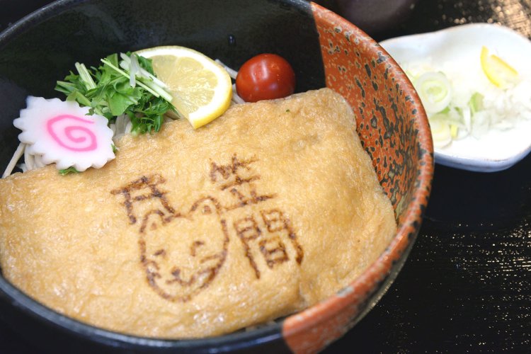 大きな油揚げが麺を覆う「稲荷そば」。お狐さんの顔もキュート。