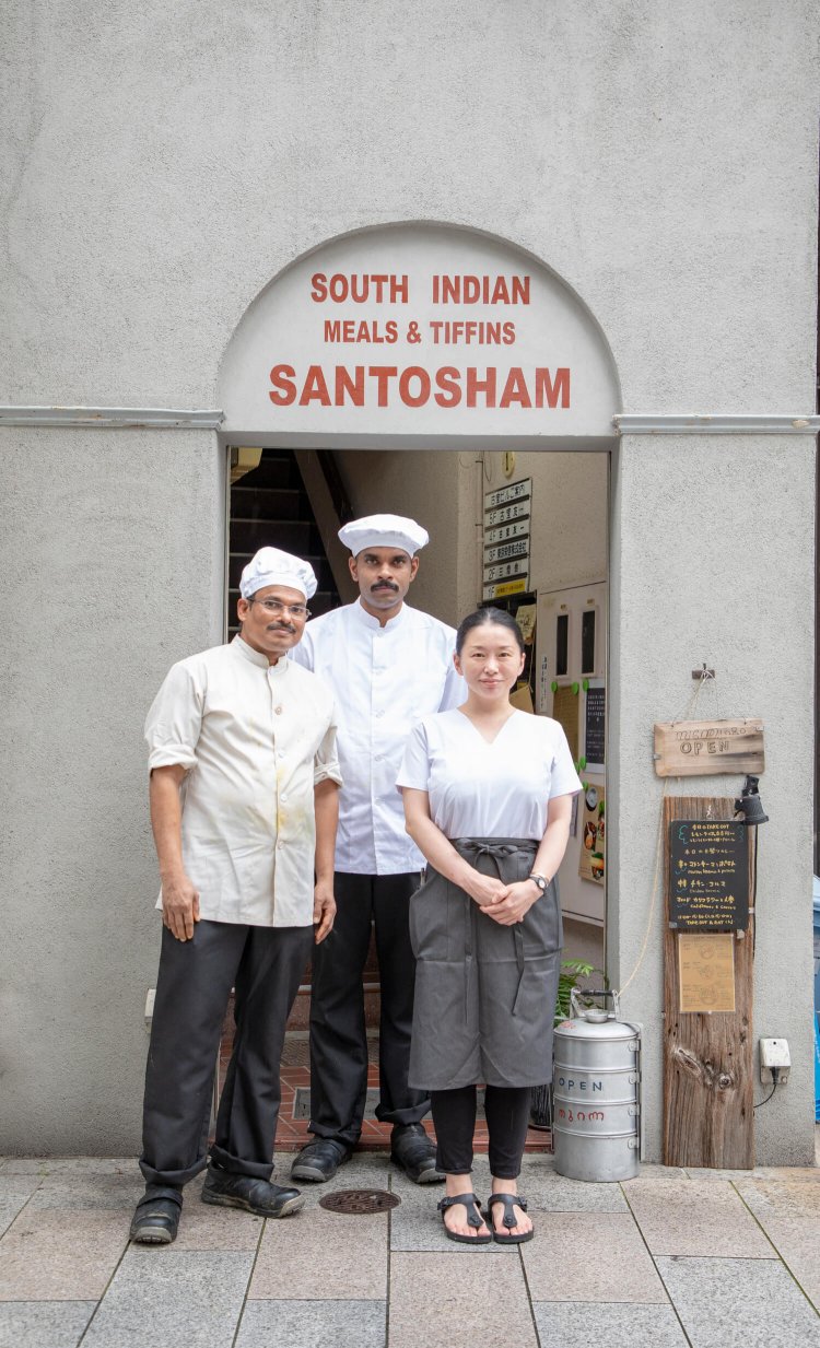 インドにある建物を模して作った店のアーチに立つのは、右から堀さん、コックのラティーシさんとトーマスさん。