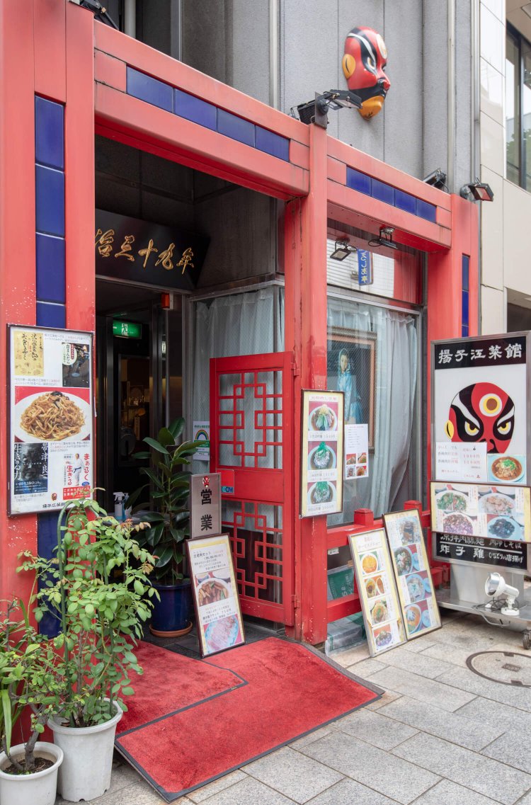赤色が目を引く入り口。店のシンボルである京劇のお面があちこちに。