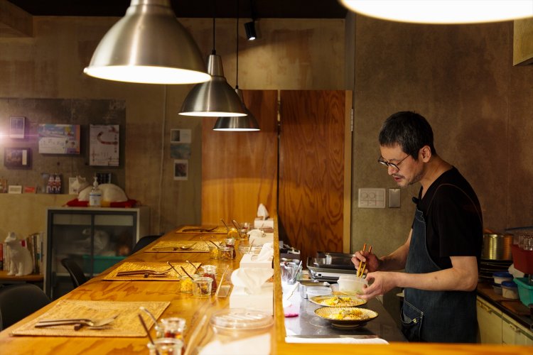 全7席のカウンターで野菜を盛る滝沢さん。「カレーのこと以外は内装も道具も結構行き当たりばったりです（笑）」。