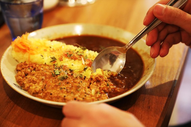 吉田さんが注文したのは、看板メニューの八月カレー＋あいがけキーマ。「トマトが効いてますね。酸味が印象的」（吉田さん）