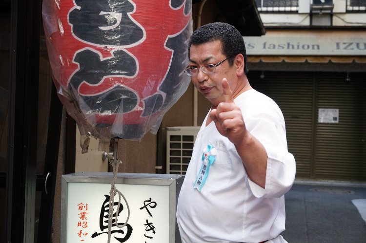 頂点からさらなる高みを目指す男、店主の伊與田さん。自ら「危険人物」のバッジを付ける。