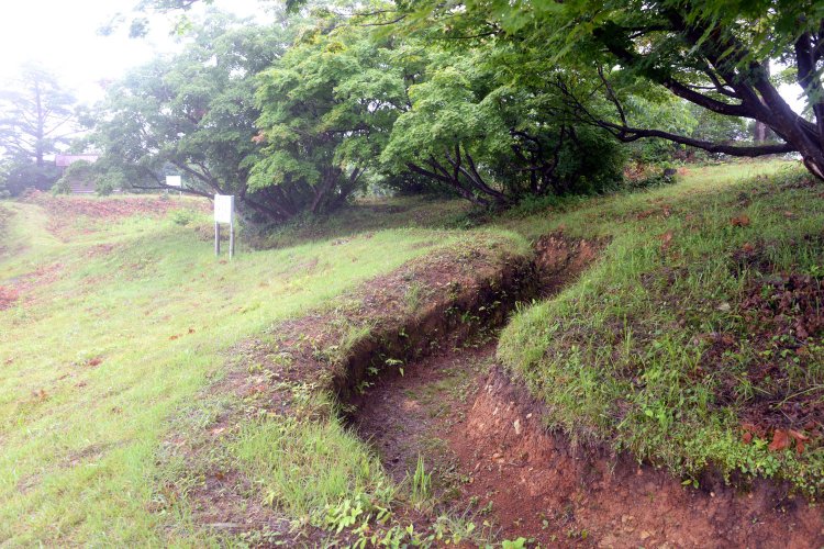 点在する墓碑を見て朝日山に上ると山頂にはフランス式塹壕が。周辺に砲台や野営場の跡もある。