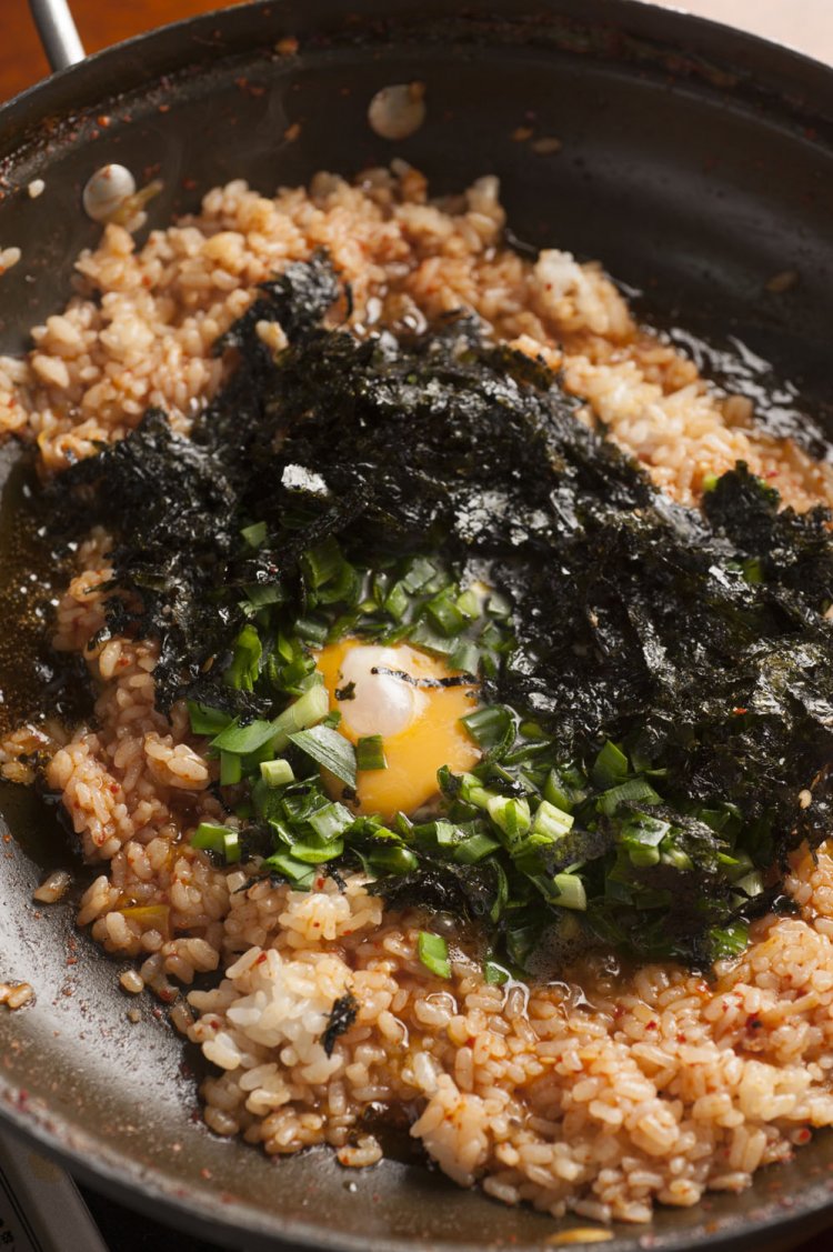 締めは韓国風おじや1人前660円で。卵と韓国ノリ、ニラなどを入れる。ごま油の風味が◎。