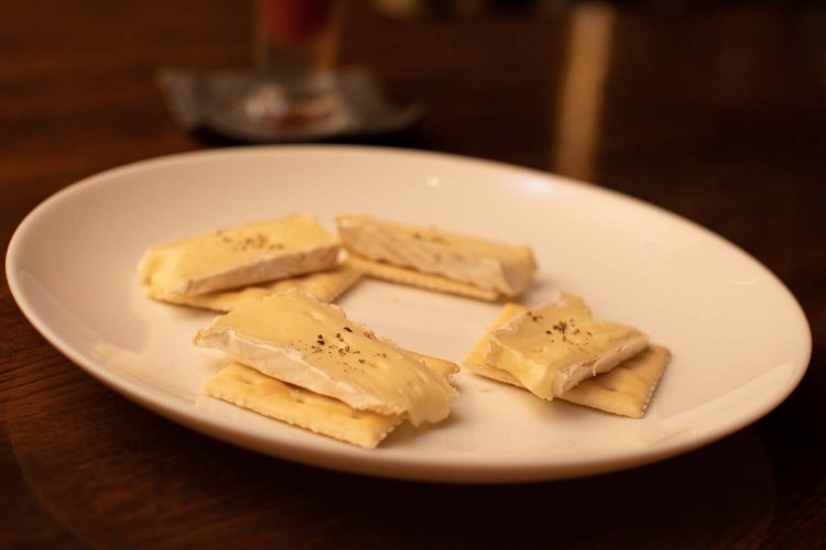 お通しのひとつ。カマンベールチーズが乗ったクラッカー。