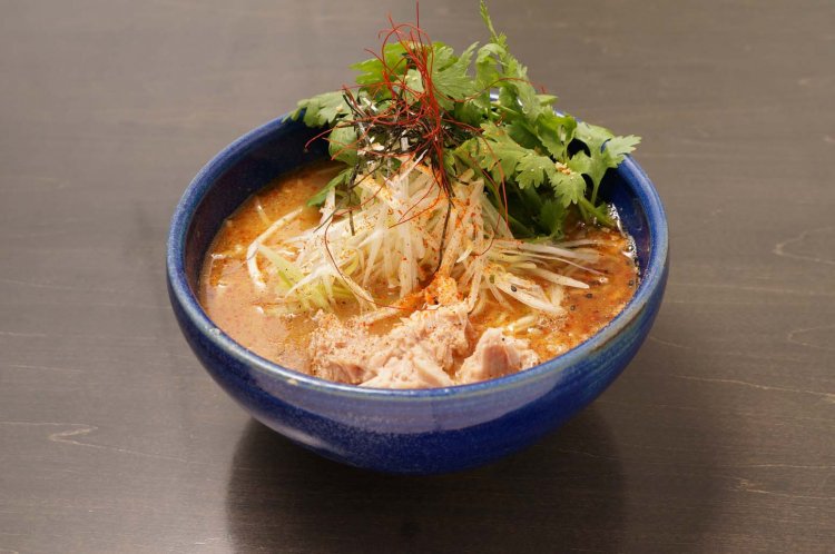 トッピングを自家製炙りベーコンかマグロのコンフィから選べるパクチースパツナラーメン1150円。