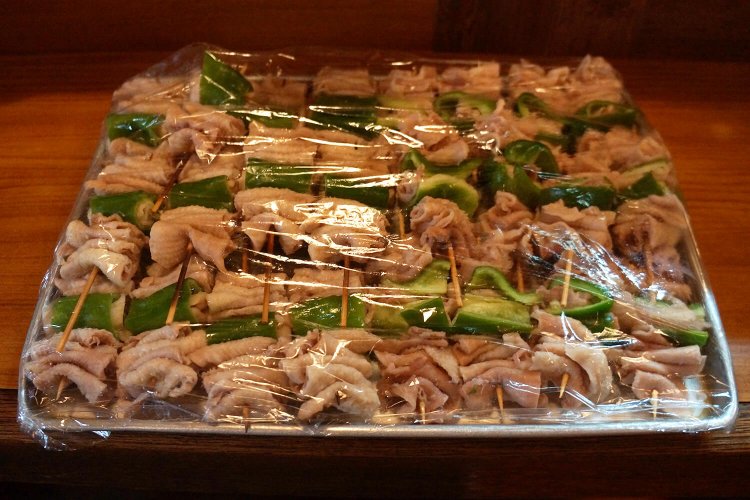 鶏皮は、いったんボイルしてからピーマンとともに串に刺す。