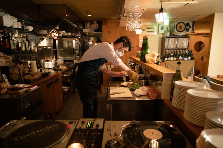 プレーヤーのすぐ横で調理する樺澤さん。「レコードにうっかり油が飛ぶことも」。