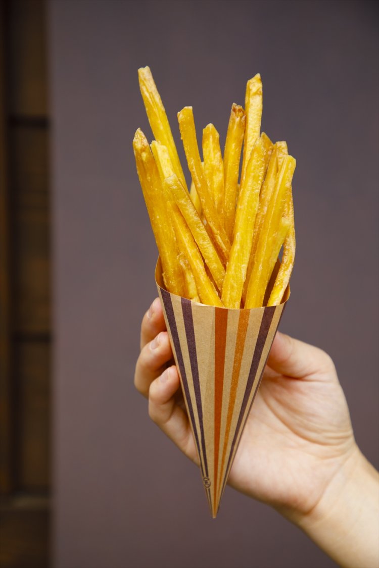 食べ歩き用 揚げたて芋けんぴ300円／揚げたてゆえ包みを持つ手に温もりを感じる。元々のサツマイモのサイズが大きいので、1本が長い。腹持ちも◎。