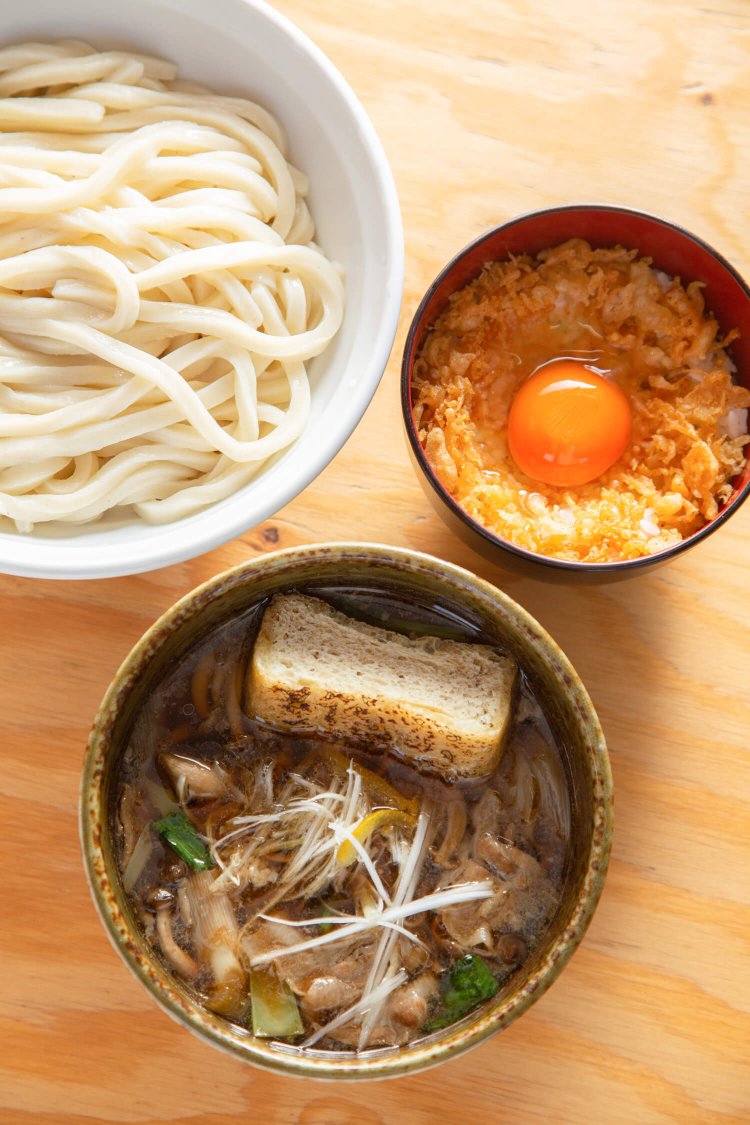 煮込んだ三元豚や栃尾揚げがのる肉汁うどん690円。名古屋コーチンの卵かけごはんセットは190円。