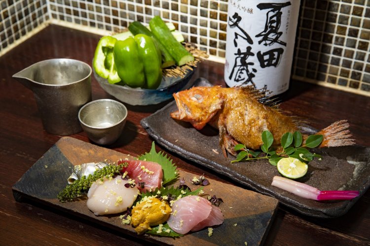 生インドマグロの中トロなど分厚いホタテ5種が彩る刺身盛1320円、焼いたキンキ1650円。夏田冬蔵純米大吟醸990円。焼酎や梅酒、ワインもそろう。