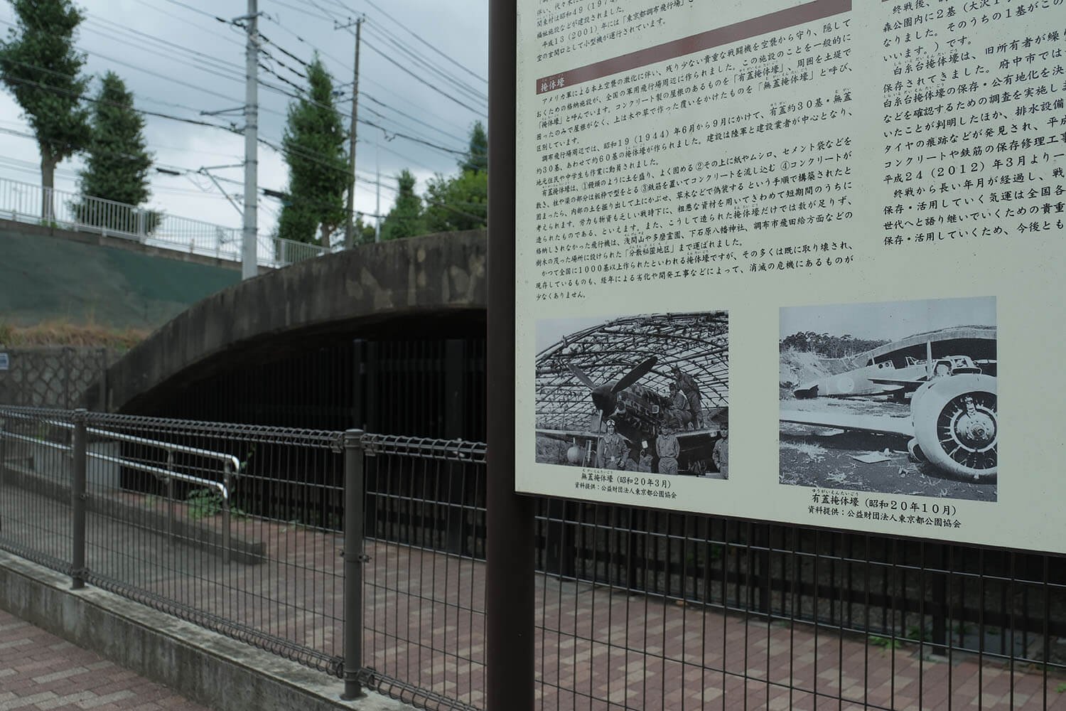 白糸台掩体壕。説明板には飛燕や五式戦闘機などの写真が掲示されている。