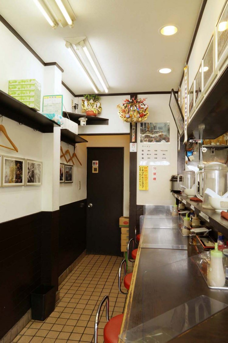 近隣の富岡八幡宮の深川八幡祭りの写真が掲げられる店内。下町の雰囲気を感じる。