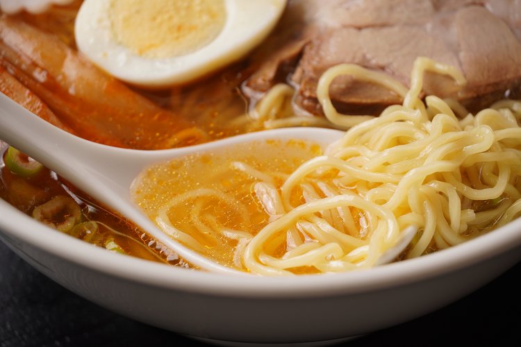 透きとおったスープにメンマのつけダレが合わさり、ほんのりオレンジ色に。