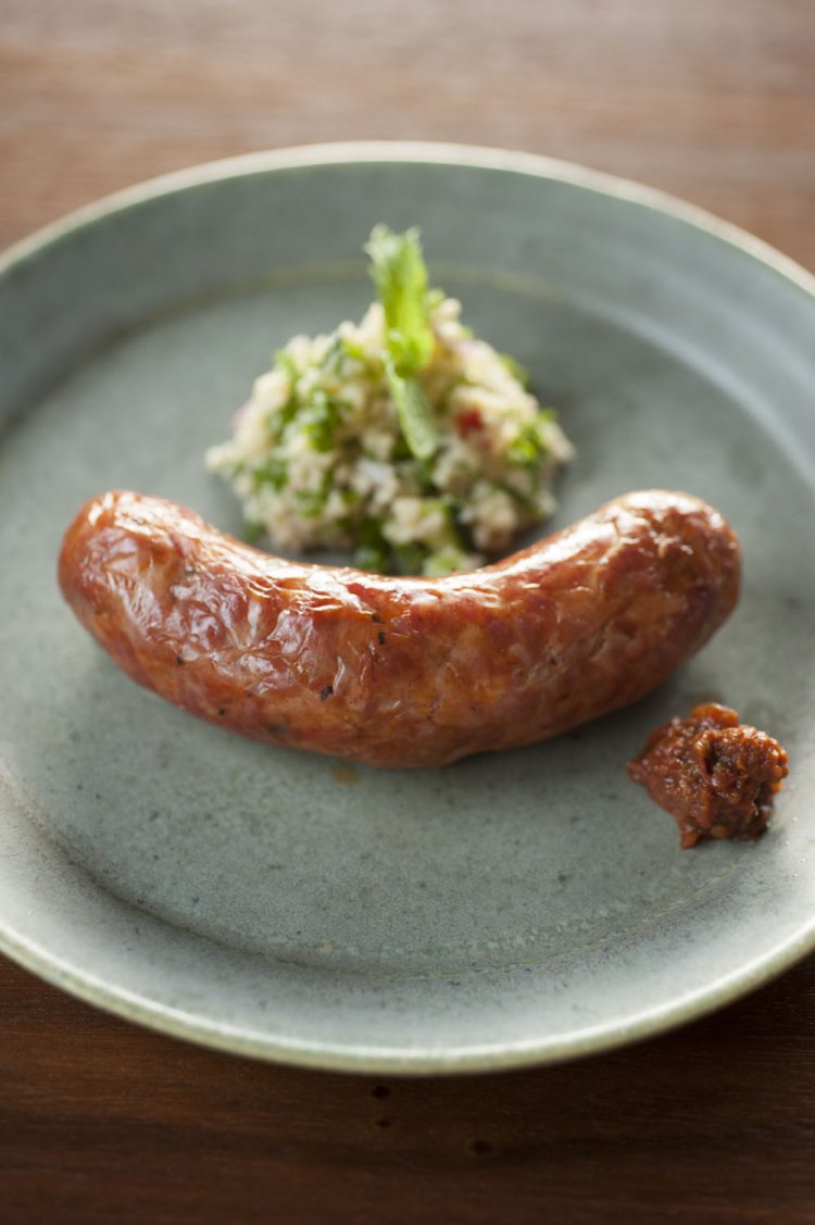 手製のクスクスのタブレと辛味調味料のアリッサが添えられた自家製ソーセージ950円は、レモンサワーと好相性。